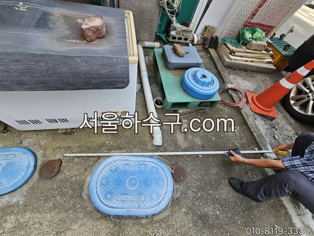 수도계량기함 뚜껑 — 단독·다가구 주택 마당의 파란 원형 뚜껑