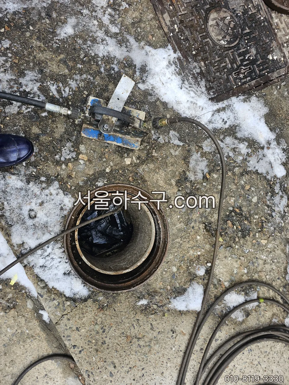 눈이 쌓인 옥외 배수구 — 고인 물이 얼어 위에서 내려온 물까지 막는 자리
