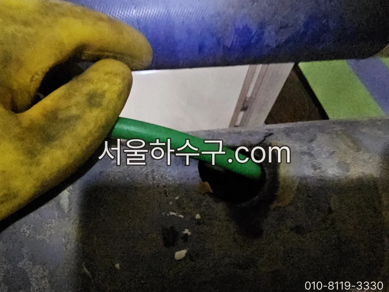 배관 입구에 고압세척 호스를 넣는 모습