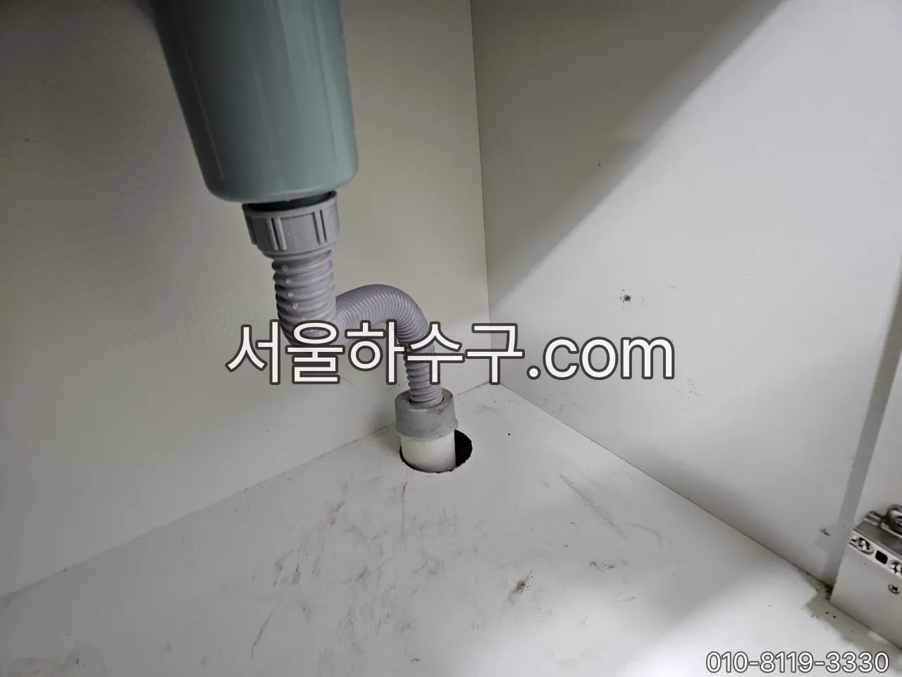 세면대 아래 P트랩 이음부를 확인하는 장면