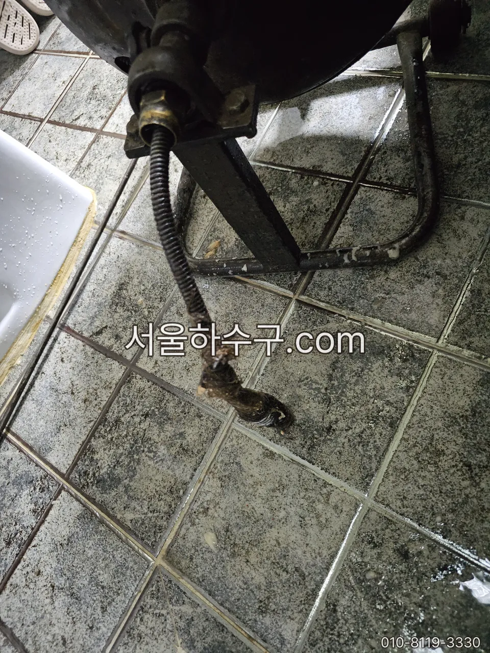 P트랩을 분해한 자리로 관통기를 넣어 벽 속 배수관을 뚫는 작업
