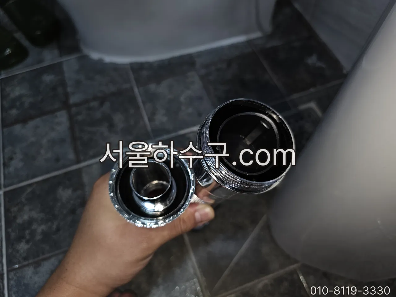 삭은 세면대 팝업(배수마개) 부속과 새 부속을 나란히 비교하는 모습
