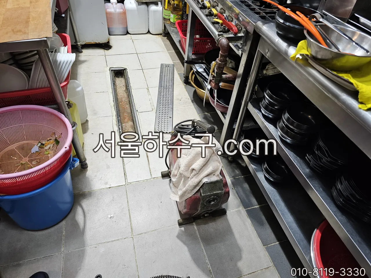 음식점 주방 바닥 트렌치에 세척 장비를 세팅하는 작업