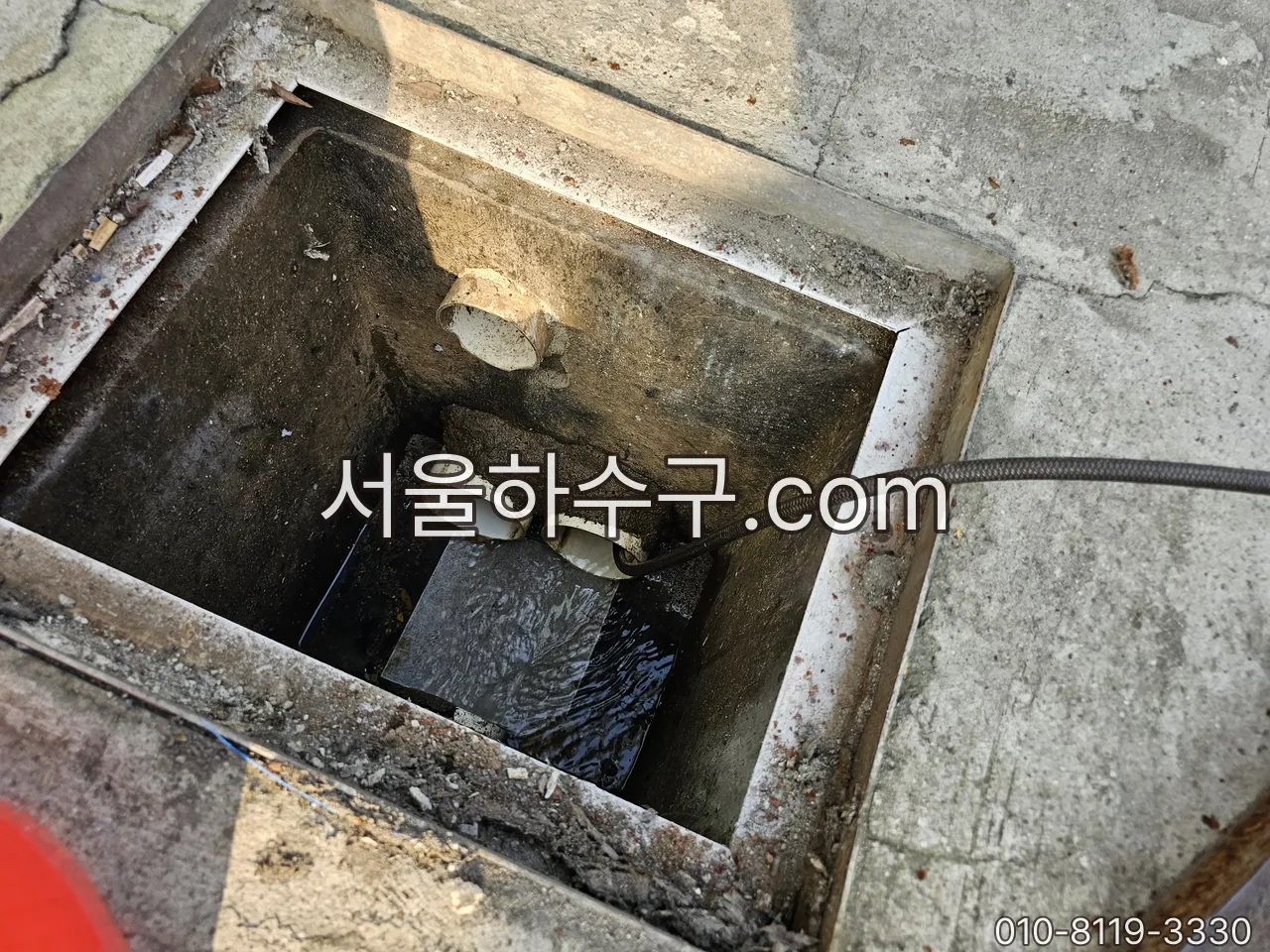 그리스트랩 배출구에 세척 호스를 넣는 작업